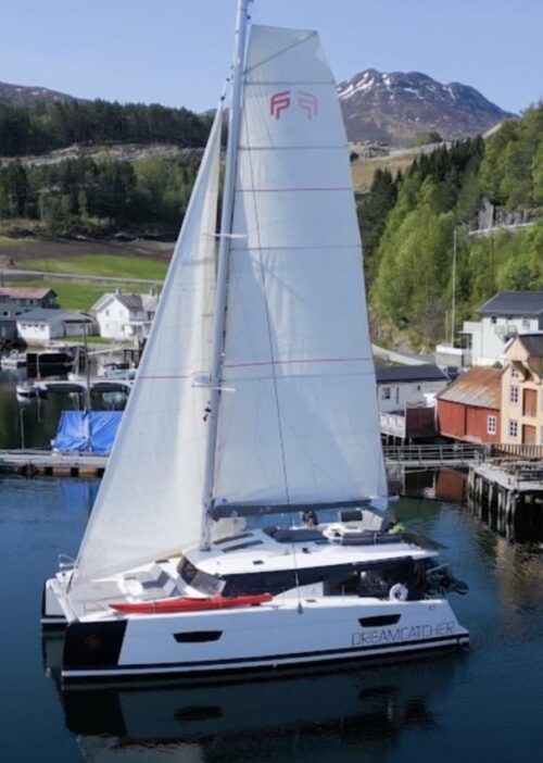 The sailing catamaran named Dreamcatcher Expedition, on the sea in a harbour